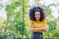 Portrait of nice afro girl smiling in a garden. Mid shot.