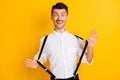 Portrait of nice attractive cheerful guy wearing white shirt pulling suspenders having fun isolated over bright yellow Royalty Free Stock Photo