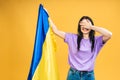 Portrait of nice beautiful lovely glad cheerful woman holding in hands Ukrainian flag having fun isolated over yellow pastel color Royalty Free Stock Photo