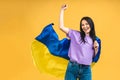 Portrait of nice beautiful lovely glad cheerful woman holding in hands Ukrainian flag having fun isolated over yellow pastel color Royalty Free Stock Photo