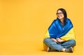 Portrait of nice beautiful lovely glad cheerful woman holding in hands Ukrainian flag having fun isolated over yellow pastel color Royalty Free Stock Photo