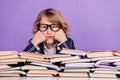 Portrait of nice bored schoolboy reading pile book science over purple violet color background