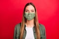 Portrait of nice charming beautiful woman keep covid-19 self-isolation wear fabric mask isolated with red background