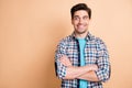 Portrait of nice cheerful guy wear checked shirt folded arms looking aside copy space isolated over beige pastel color Royalty Free Stock Photo