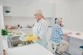 Portrait of nice cute old lady hold hand polishing drying plates wet hands enjoy house work have kitchenwear stand Royalty Free Stock Photo