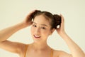 Portrait of nice cute positive pretty girl with two buns on light background