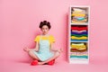 Portrait of nice focused dreamy maid organizing things sitting in lotus position meditating zen isolated on pink color Royalty Free Stock Photo