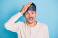 Portrait of nice funny puzzled guy wearing sleep mask oops mistake reaction isolated over bright blue color background