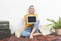 Happy attractive young woman displaying a blank white laptop screen to the camera for your copyspace and text Royalty Free Stock Photo