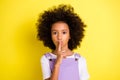 Portrait of nice pretty wavy-haired girl showing shh sign taboo isolated over bright yellow color background