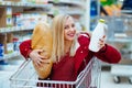 Pretty young hipster woman sitting in a supermarket trolley at the supermarket Royalty Free Stock Photo