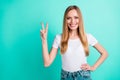 Portrait of nice sweet girl smiling making v-signs isolated over teal turquoise background Royalty Free Stock Photo