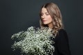 Portrait of nice woman with white flowers on black background