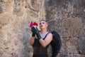 Portrait of a non-binary person, young and South American, very makeup, with black wings and leather gloves, bodice, posing with