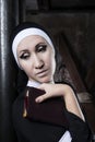 portrait of a nun in black clothes reading the bible and using a rose petal as a bookmark Royalty Free Stock Photo