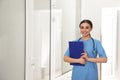 Portrait of nurse with clipboard in hallway. Medical assisting