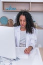 Portrait of a nurse female physician typing a medical report on her computer in the lobby