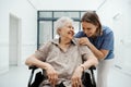 Portrait of nurse and senior patient talking in hospital corridor. Emotional support for elderly woman.