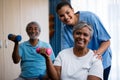 Portrait of nurse training seniors in lifting dumbbells Royalty Free Stock Photo