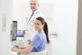 Portrait of nurse using laptop at desk with senior doctor in clinic Royalty Free Stock Photo