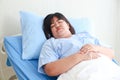Portrait of an obese female patient lying on a hospital bed.