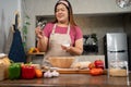 Portrait of obese woman cooking pizza in the kitchen, Raw pizza in the hands of a housewife. Homemade pizza cooking in the kitchen Royalty Free Stock Photo