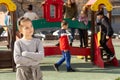 Portrait of offended girl not playing with friends after quarrel on playground