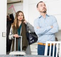 Offended man and upset woman with suitcase in doorway Royalty Free Stock Photo