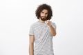 Portrait of offended outraged handsome hispanic guy with beard and afro haircut, pointing with blame at camera, frowning