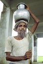 Portrait old Bangladeshi man lugging water jug Royalty Free Stock Photo