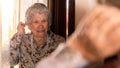 Portrait of old Caucasian woman looking at mirror in living room. Grandmother Royalty Free Stock Photo