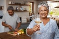 Portrait of old couple in kitchen, wine and cooking, cheers to healthy food together in home. Toast, smile and senior