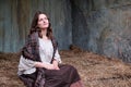 Portrait of an old-fashioned young woman sitting on a hay Royalty Free Stock Photo