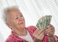 Portrait of old grey-haired woman holding dollars in hands Royalty Free Stock Photo