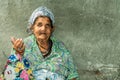 Portrait of old homeless Gypsy beggar woman with wrinkled face skin begging for money on the street in the city and looki Royalty Free Stock Photo