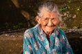 Portrait of an old Indonesian lady sitting outside.