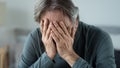 Portrait of old man covering his face with his hands Royalty Free Stock Photo