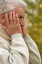 Portrait of an old man having a headache