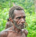 Portrait of Old man from Korowai Kolufo tribe. Green jungle natural background. Royalty Free Stock Photo