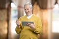 Portrait of old man uses digital tablet. Royalty Free Stock Photo