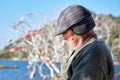 Portrait of an old man wearing a cap at the age of 60s taking a nap near the seaside on a sunny day Royalty Free Stock Photo