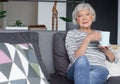 Graceful senior woman resting at home with hot tea Royalty Free Stock Photo