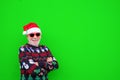 Portrait of old mature man and senior smiling and enjoying wearing christmas hat and clothes looking at the camera - green Royalty Free Stock Photo