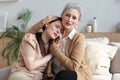 Portrait of old mother and mature daughter hugging at home. Happy trusted relations. Family concept