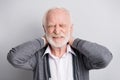 Portrait of old white hair sad man hands neck pain wear dark sweater isolated on grey background Royalty Free Stock Photo