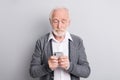 Portrait of old white hair serious man type telephone wear dark sweater isolated on grey background