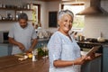 Portrait of old woman at kitchen counter with man, tablet and cooking healthy food together in home. Digital recipe Royalty Free Stock Photo
