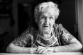 Portrait of an old woman sitting in her home. Black and white photo. Royalty Free Stock Photo