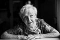 Portrait of an old woman sitting in her home. Black-and-white photo. Royalty Free Stock Photo