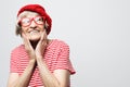 portrait of old woman wearing glasses and red hat smiling with hand on face. Royalty Free Stock Photo